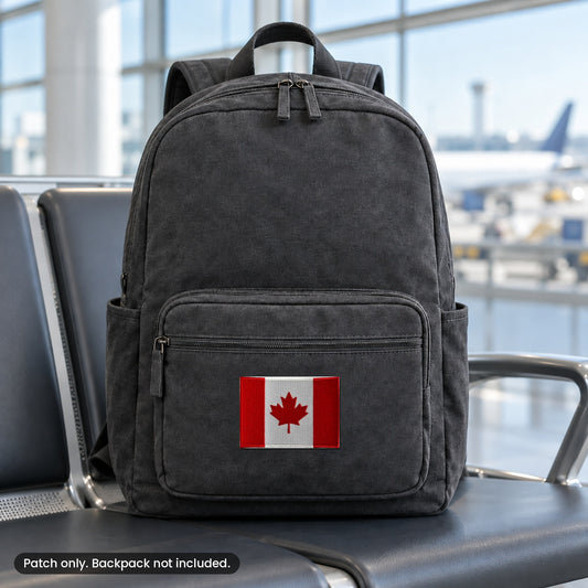 Canada flag patch on a black travel backpack in an airport, backpack not included